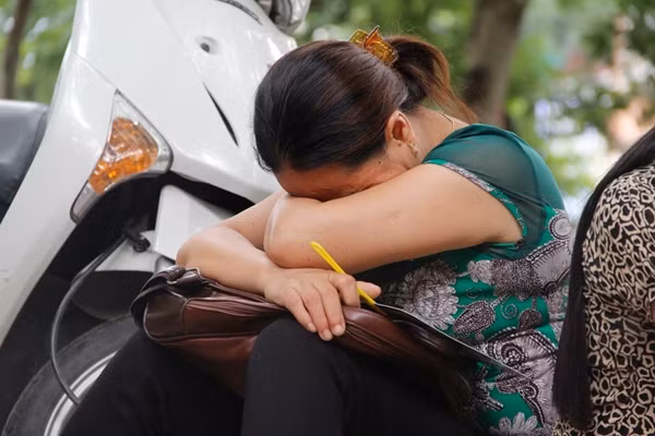 Trong khi các thí sinh ngồi trong phòng thi làm bài thì phía ngoài nhiều phụ huynh tỏ ra mệt mỏi do thời tiết oi bức. Một số phụ huynh tranh thủ ngủ gục để đợi con.