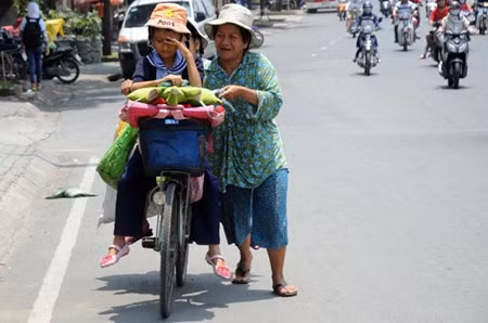 Bà Nguyễn Thị Mai (ngụ quận Bình Thạnh) đang chở con gái từ trường học ở quận 3 về vào giữa trưa. Em bé tỏ ra mệt mỏi khi trời chang nắng.