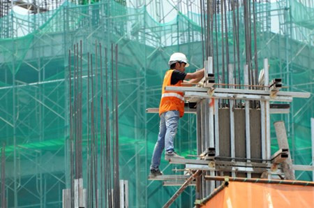 Một công nhân làm việc vào thời điểm 13h, khi trời nắng nóng nhất ở tuyến tàu điện ngầm Metro dọc đường Xa Lộ Hà Nội (quận 2).