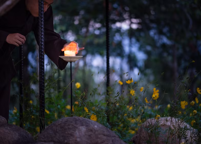 Khi trời sẩm tối, các nhà tu, phật tử có thể thắp nến trên một kệ ngay bên cạnh đó.