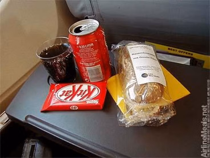 Bữa sáng gồm bánh mỳ sandwich, nước ngọt và một thanh socola.