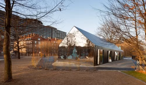 Hai mặt chiều dọc của ngôi nhà vô hình này được lát ván gỗ hóa nhiệt. Các cánh cửa được thiết kế theo dạng cửa xoay, với mặt trong là những mặt gương cong có thể xoay ngược ra ngoài thu hút trẻ em đến nhìn ngó bóng mình bị biến dạng trong gương.