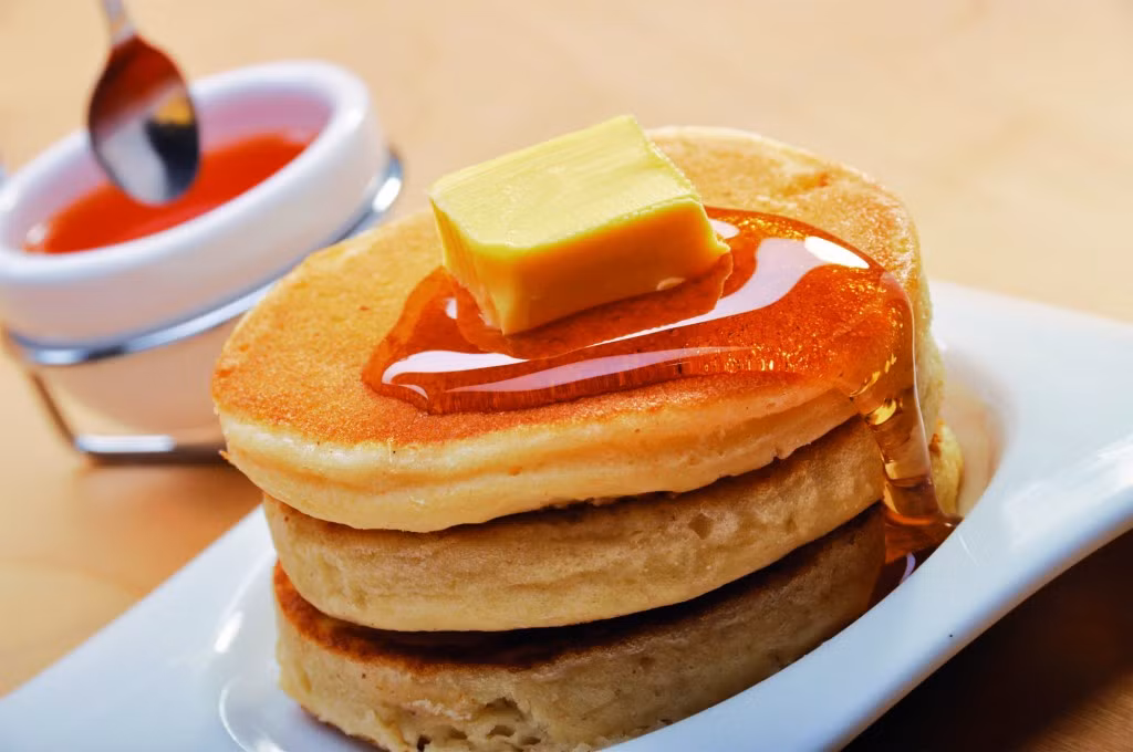 Pancake. Là một loại bánh được xếp chồng với nhau bởi 3 miếng bánh nhỏ, phía trên bánh là miếng bơ kem nguyên chất được rưới lên một ít mức xi rô ngọt ngào. Đây là món ăn tuyệt vời dành cho bữa ăn sáng.