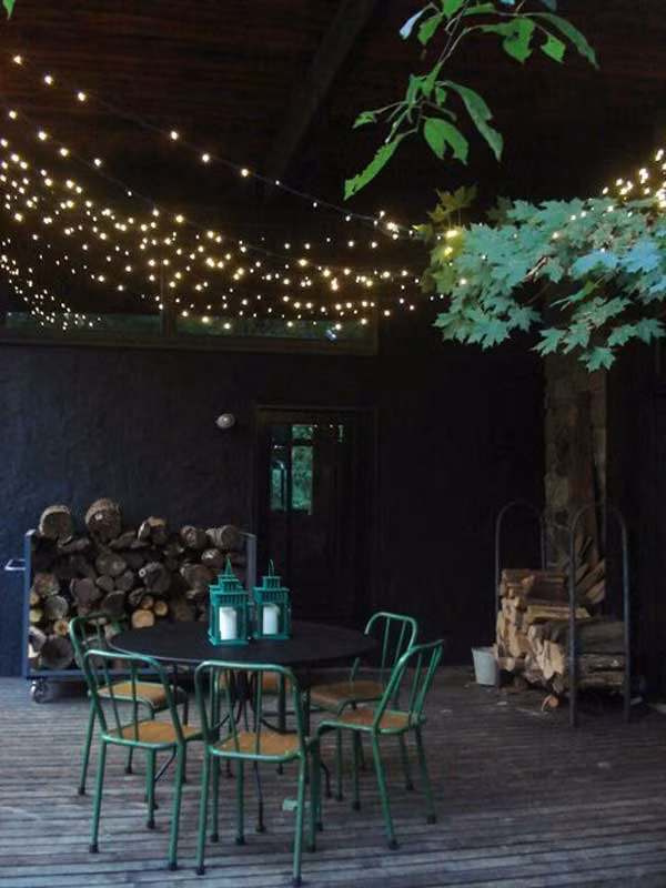 Chỉ cần giăng những dây đèn nhấp nháy cố định trên cao, bạn đã có một không gian ăn tối đầy lãng mạn khi thắp chúng lên.