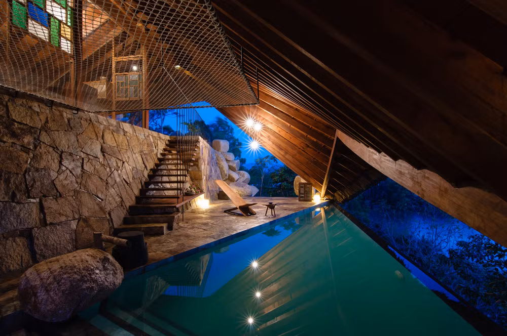 Xuống đến tầng bên dưới là bể bơi nước khoáng với một bộ ghế gỗ nằm thư giãn nhìn ra dòng sông bên dưới.