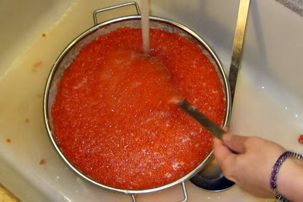 Ngâm trong vòng 15 phút thì trút toàn bộ số cá hồi ra rổ lưới để lọc cho khô nước.