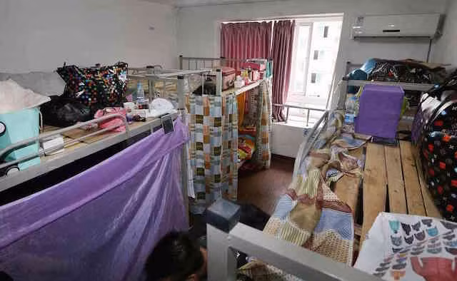 Mỗi giường có lắp thêm tấm ri-đô ngăn cách, la liệt móc phơi quần áo, thậm chí chăn màn chiếu gối, đồ đạc lộn xộn khắp nơi.