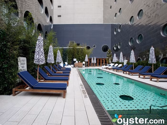 Còn thực tế, bể bơi khá mảnh mai và bị lọt thỏm giữa hai tòa nhà cao tầng.