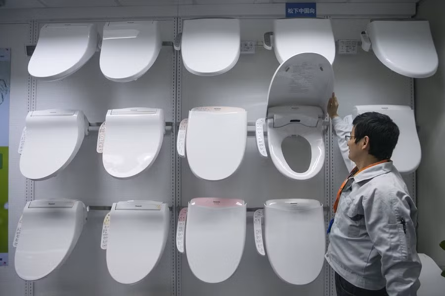 Một nhân viên đang kiểm tra chiếc nắp bô toilet tại nhà máy ở Hàng Châu.