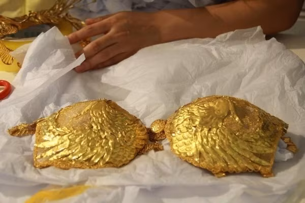 Chiếc áo lót được chạm trổ cặp chim phượng rất tinh xảo đi kèm với chiếc quần lót cũng bằng vàng rất mỏng manh. Không chỉ khắc hình các con vật quý hiếm như rồng, phượng hoàng, trên chiếc áo còn có dòng chữ tên của cửa hiệu vàng.