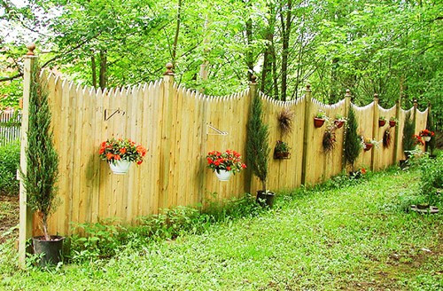 Với những tường rào bằng gỗ đơn điệu, bạn có thể treo thêm vài giỏ hoa rực rỡ sắc màu.