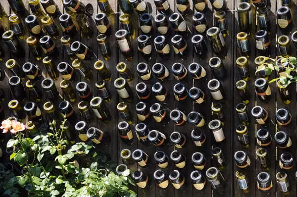 Để tiết kiệm chi phí, bạn có thể trang trí tường rào đẹp với những vỏ chai rượu.