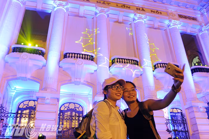 Rất nhiều người đã tranh thủ ghi lại những khoảnh khắc lung linh tuyệt đẹp của Nhà hát Lớn Hà Nội trong đêm tiệc ánh sáng này. (Ảnh: Việt Linh)