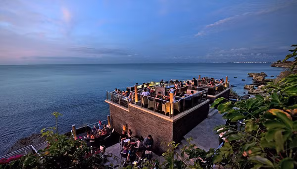 Quầy Rock bar của resort &amp; spa Ayana ở Bali, Indonesia, nằm trên độ cao gần 20 m ngay sát bờ vực đá cạnh biển Ấn Độ Dương. Quán bar trong khách sạn hạng sang này có view nhìn ra biển xanh trong, mát mẻ.