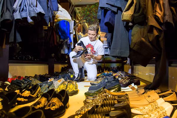 Nam ca sĩ đang chọn một đôi giày trong số rất nhiều phụ kiện dát vàng của mình.