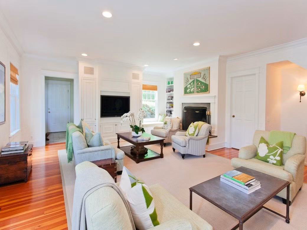 Phòng khách được thiết kế nội thất màu trắng sữa với màu xanh lá dịu mắt và sang trọng.