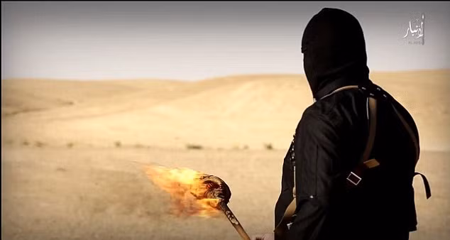 Một trong những chiến binh đang cầm ngọn đuốc để chuẩn bị đốt một rãnh dầu đã được đào dẫn tới vị trí các tù nhân bị xích.