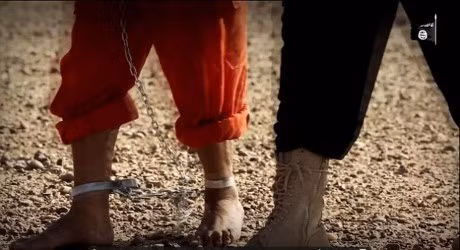 Mỗi chiến binh IS (mặc đồng phục đen) dẫn giải một tù nhân bước vào sa mạc.