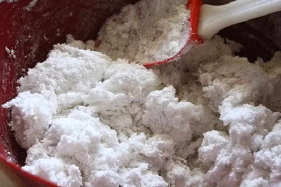 Cho chảo lên bếp, khi dầu nóng, bạn cho hành tím vào phi thơm rồi cho hỗn hợp nhân vào đảo đều. Khi thấy hỗn hợp nhân chuyển qua màu vàng thì cho hết phần hành lá băm nhỏ vào đảo tiếp rồi tắt bếp. Trộn đều bột gạo cùng bột năng. Ảnh: toinayangi.vn.