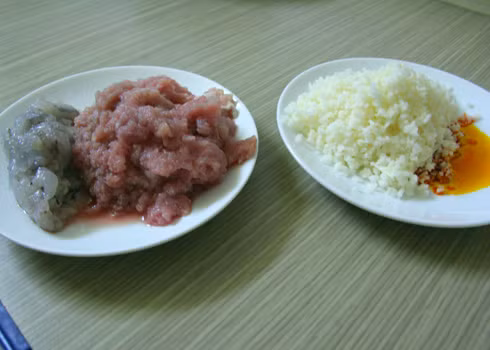 2. Bánh nậm. Nguyên liệu: Bột gạo, bột năng, nước, dầu ăn, tôm, thịt lợn xay, hành lá, hành tím, gia vị, lá dong. Tôm lột vỏ, băm nhuyễn, trộn cùng thịt xay, ướp cùng nước mắm, muối, bột ngọt trong 15 phút. Ảnh: Lamsao.com.