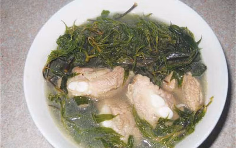 Cho sườn đã ướp vào nồi đổ nước rồi nấu sôi, giảm bớt lửa, hớt bọt cho nước trong, nấu đến khi sườn chín mềm thì đinh lăng vào, nấu tiếp cho canh thơm dậy mùi đinh lăng thì tắt lửa, nêm vừa ăn. Múc canh ra bát ăn chung với cơm nóng. Ảnh: Cooky.vn.