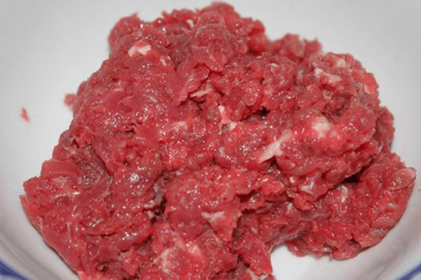 Sau khi nhào bột xong để bột nghỉ 20 phút. Trong khi chờ bột nghỉ chúng ta ướp thịt bò. Cho thịt bò vào bát, 1 muỗng nhỏ nước mắm, tỏi đập nhuyễn, 1 nửa muỗng mì chính, 1 chút tiêu và một chút dầu thực vật cho thịt bò mềm mại không dai. Ảnh: Monngon.tv.