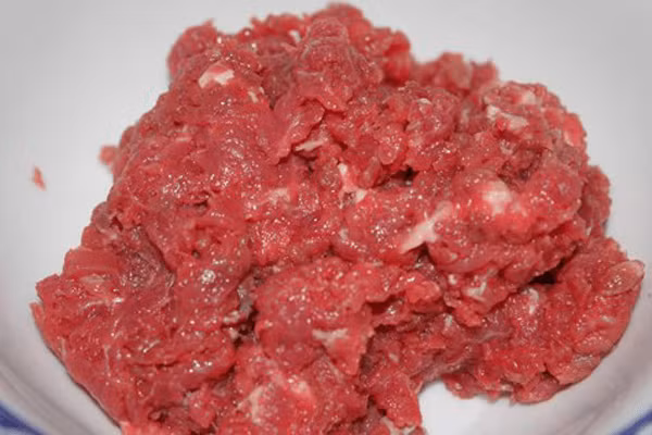 Sau khi nhào bột xong để bột nghỉ 20 phút. Trong khi chờ bột nghỉ chúng ta ướp thịt bò. Cho thịt bò vào bát, 1 muỗng nhỏ nước mắm, tỏi đập nhuyễn, 1 nửa muỗng mì chính, 1 chút tiêu và một chút dầu thực vật cho thịt bò mềm mại không dai. Ảnh: Monngon.tv.