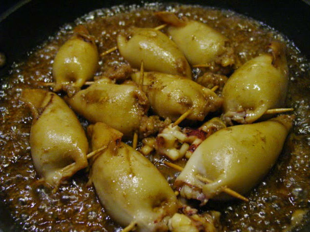 Thêm nước mắm, hạt nêm, đường, bột năng, mì chính, chút tiêu rắc đều. Trộn thật đều hỗn hợp đến khi nào hỗn hợp thật dẻo dai, chắc tay. Nhồi hỗn hợp trên vào con mực, vừa nhồi vừa dùng thìa nén lại, không nhồi quá đầy, sau đó lấy tăm nhọn xiên phần trên của mực lại. Ảnh: BepGiaDinh.com.