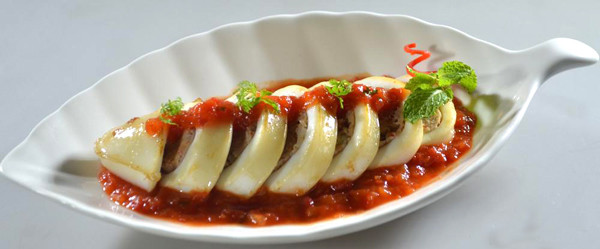 Cho mực đã hấp chín vào, đun với lửa nhỏ thêm 5-10 phút cho mực ngấm gia vị là được. Xếp xà lách, cà chua cắt lát ra đĩa, mực ống cắt khoanh, xếp lên trên, rưới thêm nước sốt rồi dùng nóng. Ảnh: baoninhthuan.com.vn.