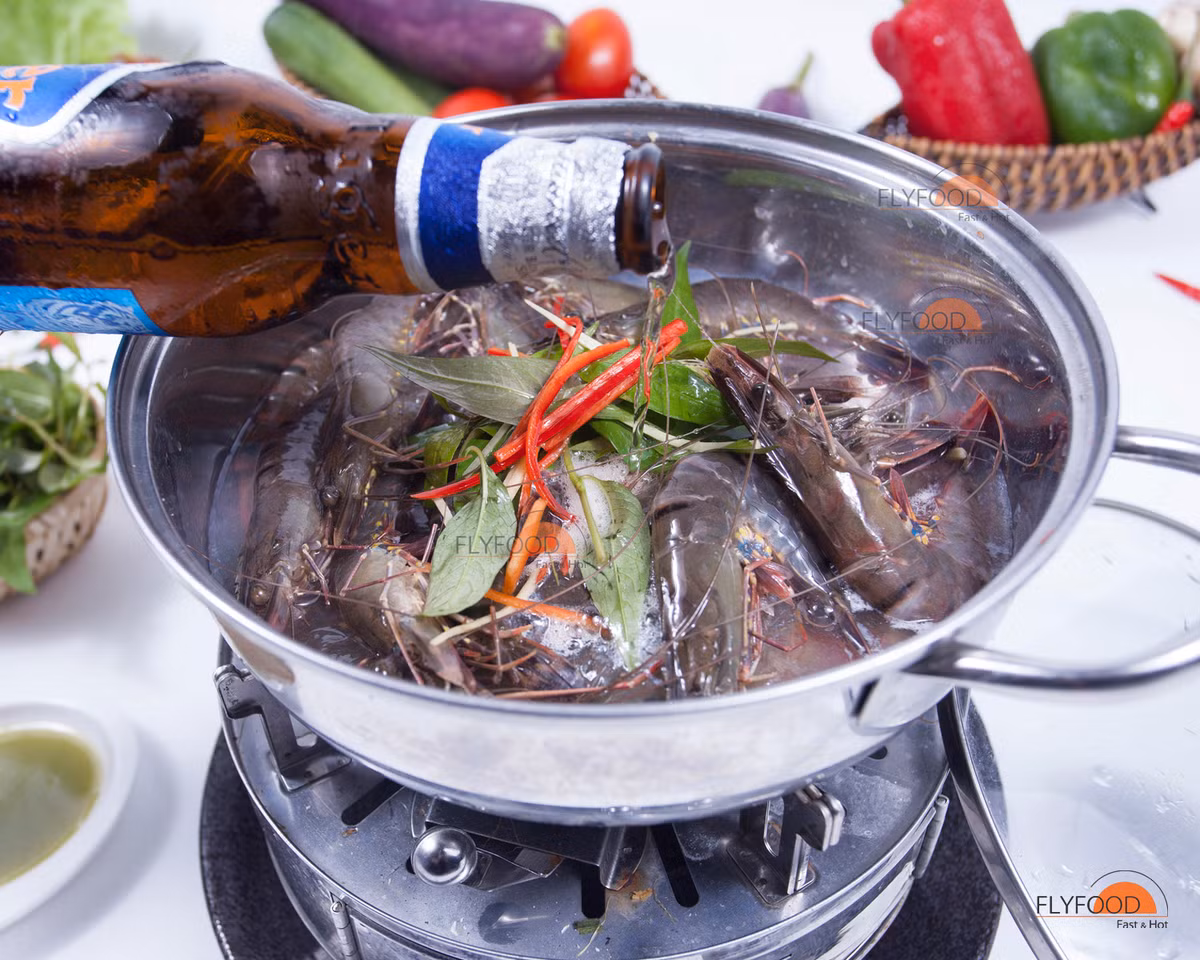2. Tôm sú hấp bia. Nguyên liệu: Tôm sú, muối ớt xanh, lon bia. Tôm rửa sạch, cho vào nồi hấp. Đổ bia vào nồi tôm, đậy lại rồi hấp với lửa lớn. Ảnh: FlyFood.vn.