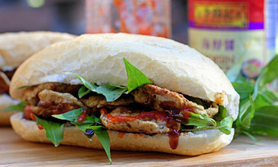 Chả cá cắt thành những miếng vừa ăn, sau đó chiên sơ cho chả cá nóng lên. Bánh mì cắt dọc một bên và rắc một ít muối tiêu lên 2 mặt, tiếp theo cho tương ớt lên. Tiếp tục xếp chả cả vào, rồi thêm một ít đồ chua, ngò rí, rau răm và sắt ớt trái lên mặt. Ảnh: Emvaobep.com.