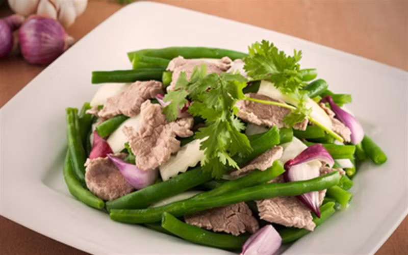 Nêm chút hạt nêm, cho thêm 1 chút nước để đỗ mềm và xanh. Đỗ gần chín thì đổ thịt bê đã xào vào, nêm bột ngọt, đảo đều rồi tắt bếp, rắc thêm chút tiêu. Ảnh: Cooky.vn.