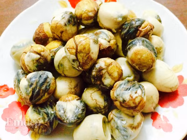 Trứng cút lộn sau khi chiên cho vào chảo nước sốt me đun sôi và tiếp tục đun lửa liu riu trên bếp. Nhẹ tay lật trứng cho ngấm đều nước sốt me, chừng 3-4 phút là được. Ảnh: kenhphunu.com.