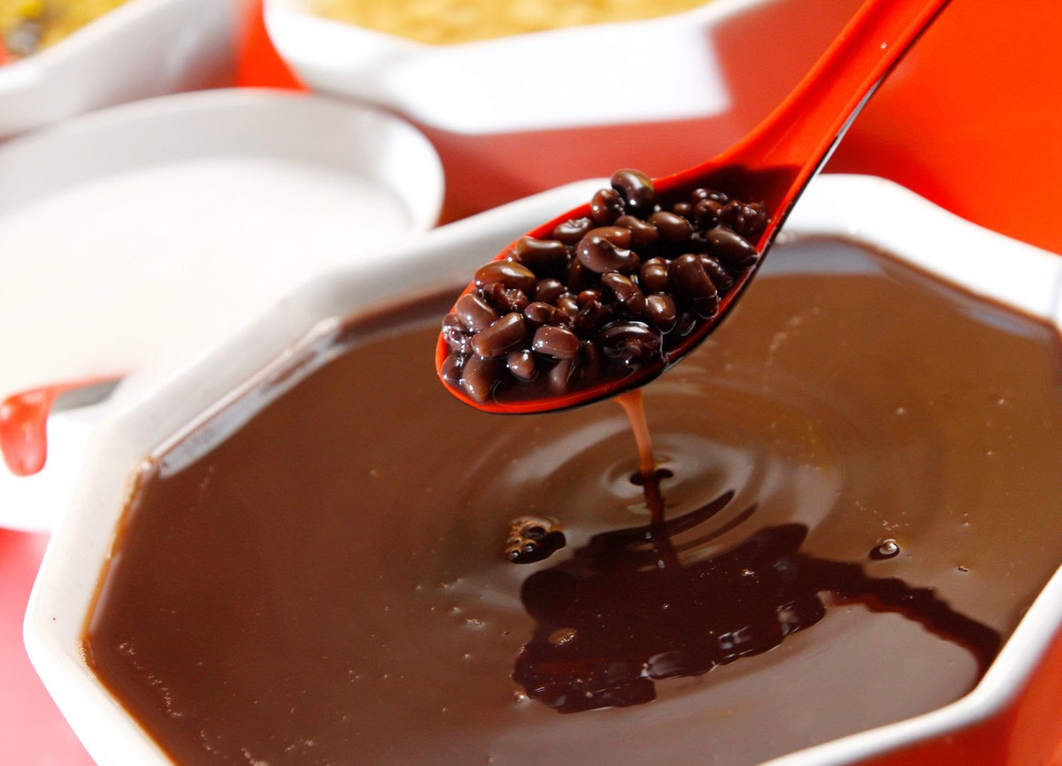 Chắt bớt nước trong nồi chè ra bát, rồi đổ đường vào khoảng 200-300gr, đun cho tan đường, đảo nhẹ nhàng rồi tiếp tục đậy vung, đun trong vòng 10 phút cho đường ngấm vào đỗ. Chế thêm nước vào nồi chè, rồi đun sôi trở lại. Đổ nước cốt dừa vào nồi chè, đun sôi tiếp rồi tắt bếp. Ảnh: JAMJA.vn.