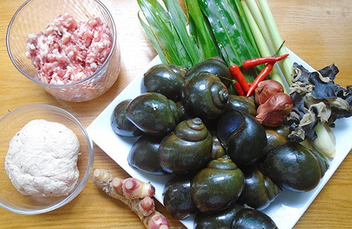 2. Ốc nhồi thịt hấp lá gừng. Nguyên liệu: Ốc nhồi to, thịt nạc vai, tiêu, gừng, đường, lá chanh, giò sống, nấm hương, lá gừng, dấm, ớt, nước mắm, mì chính. Ốc bươu mua về rửa sạch rồi cho vào một nước để luộc chín. Cho vài nhánh sả cho thơm. Luộc trong vòng 10-15 phút. Ảnh: mevaobep.com.