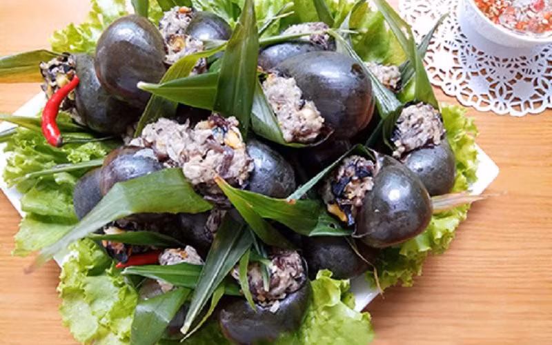 Nhồi ốc. Đặt một lá gừng vào giữa miệng vỏ ốc sau đó cho thịt vào để ấn lá gừng xuống dưới. Nhồi thịt cho đầy miệng ốc để trông thật đẹp mắt. Hấp ốc. Ốc hấp cách thủy trong vòng 15-20 phút. Pha nước chấm. Nước chấm pha cùng tỏi và ớt để chấm cho vừa khẩu vị của mọi người. Ảnh: Cooky.vn.