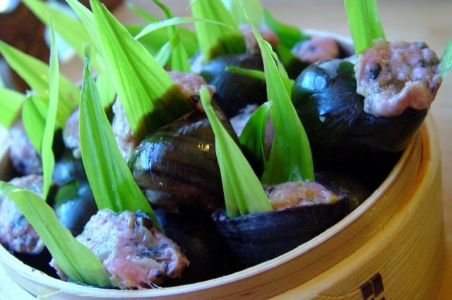 Ốc luộc xong để nguội rồi bắt đầu lấy một que tăm để khều thịt ốc ra và giữ lại vỏ ốc. Rửa vỏ ốc bằng nước sạch để ráo nước. Đục 1 lỗ ở đáy vỏ ốc để vào rổ cho khô đợi nhồi thịt. Thịt ốc băm nhuyễn. Chuẩn bị một bát to cho hỗn hợp thịt xay, ốc, mộc nhĩ, nấm hương, nước mắm, hạt nêm vào trộn đều tay. Ảnh: forum.medihub.vn.