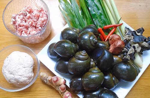 2. Ốc nhồi thịt hấp lá gừng. Nguyên liệu: Ốc nhồi to, thịt nạc vai, tiêu, gừng, đường, lá chanh, giò sống, nấm hương, lá gừng, dấm, ớt, nước mắm, mì chính. Ốc bươu mua về rửa sạch rồi cho vào một nước để luộc chín. Cho vài nhánh sả cho thơm. Luộc trong vòng 10-15 phút. Ảnh: mevaobep.com.