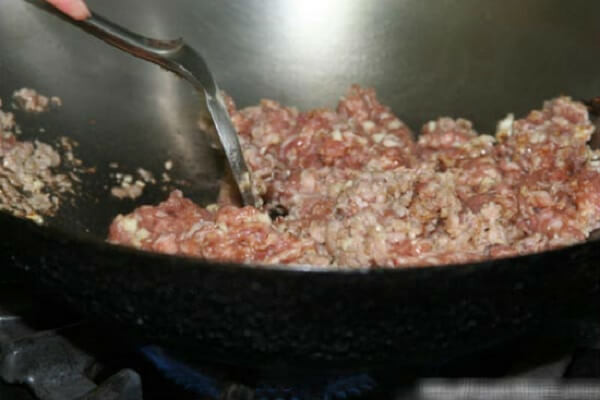 Bắc chảo lên bếp cho vào đó một ít dầu ăn và để dầu hơi nóng xào thịt trên chảo cho đến khi chín và cho tiếp tỏi, hành và gừng đã băm nhỏ vào. Tiếp theo cho mực vào xào cùng, thêm cần tây và một ít rượu trắng để món ăn thêm đậm đà. Ảnh: monngon.tv.