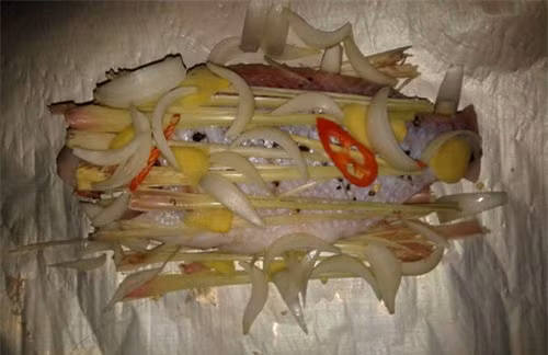 2. Cá nướng giấy bạc. Nguyên liệu: Cá điêu hồng, mẻ, mắm tôm, nghệ xay, hành khô, tỏi băm nhỏ, gia vị: xì dầu, hạt nêm, đường, dầu hào, giấy bạc, hành lá, ớt, chanh, thì là. Cá khía chéo ở 2 bên thân, rửa sạch với muối, rượu trắng cho hết tanh. Ảnh: anchoiodau.com.