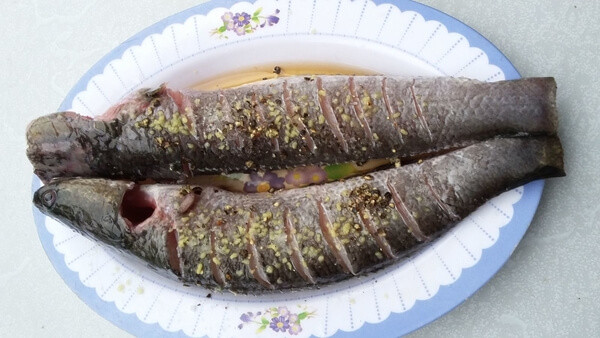 Sả, gừng, hành khô đem xay hoặc giã nhỏ vắt lấy nước cốt xoa đều lên hai mặt cá, còn phần bã đem ướp vào trong bụng cá. Lấy 1 thìa bột nêm và mì chính xoa đều thân cá. Để ướp khoảng 30 phút cho cá ngấm rồi đem chiên cá chín tới. Ảnh: emvaobep.com.