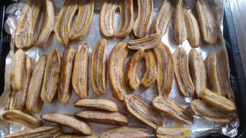 Sau khi kết thúc thời gian sấy, bạn kéo khay ra, dùng kẹp thực phẩm lật các miếng chuối lại và phun tiếp phần nước chanh + vani như với mặt trước. Chuối được sấy khô, chín là khi chuối có màu vàng nâu, tươi, không bị cháy và có được mùi thơm đặc trưng. Ảnh: afamily.vn.