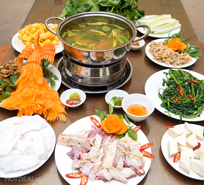 Cho khoai môn và nấm hương vào xào, đảo đều tay để gia vị được thấm đều lên vịt. Sau đó, đổ nước dừa xiêm và nước lạnh vào. Bật lửa đun sôi đều trong khoảng 1 giờ đồng hồ. Khi thịt vịt đã chín mềm, cho phần măng đã xào và phần đậu phụ thái nhỏ vào, thêm váng đậu vào và đặt lên bếp từ dùng nóng. Ảnh: Hotdeal.vn.