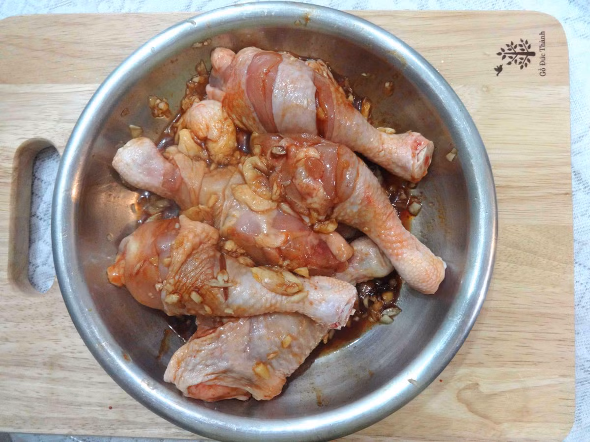 2. Gà nướng tỏi. Nguyên liệu: Đùi gà ta, tỏi, hành tím, sả, ớt, gừng, bột nghệ, bột me, gia vị, rau ăn kèm: xà lách, cải xoăn, dưa chuột. Đùi gà làm sạch, dùng dao lọc bỏ hết phần mỡ dính trên đùi gà, để ráo, không ướp gia vị. Ảnh: BepGiaDinh.com.