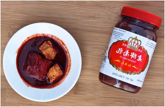 3. Gà nướng chao đỏ. Nguyên liệu: Gà ta, chao đỏ, mật ong, dầu hào, rượu, sả, hành tím, hành lá, gừng, bột ngọt, ớt bột. Gà rửa sạch, chặt miếng vừa ăn. Nghiền nhuyễn các viên chao đỏ, trộn với bột ngọt, dầu hào, mật ong, rượu, hành tím bằm, sả bằm, ớt bột thành hỗn hợp ướp. Ảnh: daubepchinhquy.wordpress.com.