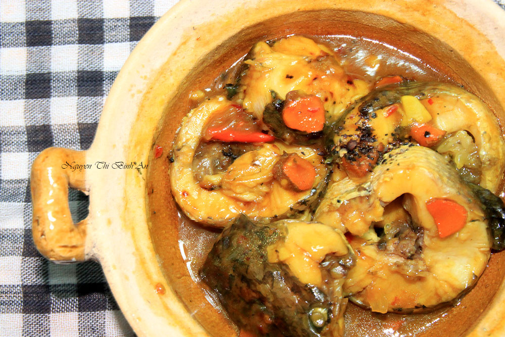 Làm sạch cá. Ướp cá với tinh bột nghệ, nước mắm, đường, bột nêm, hành băm, ớt băm khoảng 15 phút cho ngấm. Cho cá vào nồi, cho nước dừa tươi, dầu ăn vào, đun trên lửa nhỏ cho đến khi nước kho sánh lại. Dọn cá ra đĩa, xếp vài lát nghệ lên trên. Ảnh: anvietnam.net.