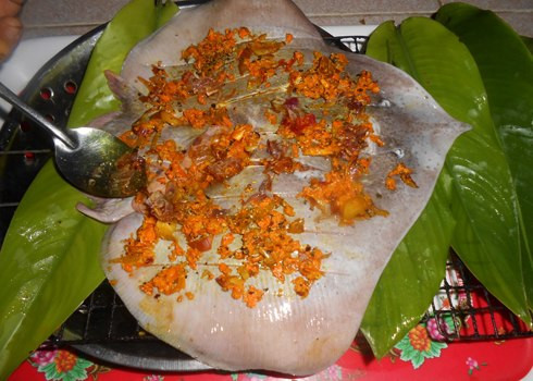 3. Cá đuối nướng nghệ. Nguyên liệu: Cá đuối, lá gừng, tinh bột nghệ, tỏi, hành tím, chanh, ớt tươi, nước mắm, muối, tiêu. Để nguyên cả con cá và dùng dao nhọn cắt dọc trên thân cá theo từng đường nhỏ để khi ướp cá dễ thấm gia vị hơn. Ảnh: monvietngon.vn.