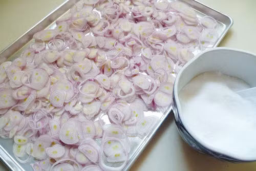 Khi dầu đã đủ nóng thì cho toàn bộ hành đã phơi vào để phi. Trong quá trình phi, thỉnh thoảng dùng đũa đảo nhẹ tay cho hành ngập đều trong dầu nóng. Khi thấy hành bắt đầu ngả vàng nhẹ thì tắt bếp và tiếp tục dùng đũa đảo nhẹ tay cho đến khi hành khô lại và có màu vàng đẹp. Ảnh: TinyBook.net.