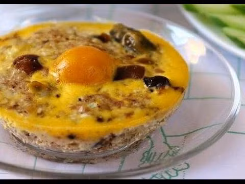 Đập trứng trong một bát lớn đánh đều và dùng một cái rây lược từ từ phần trứng này vào tô thịt, nấm và dùng muỗng gạt bằng. Rải lên mặt tô trứng phần lòng đỏ trứng muối đã cắt hạt lựu và đem hấp cách thuỷ khoảng 25 phút. Ảnh: youtube.vn.