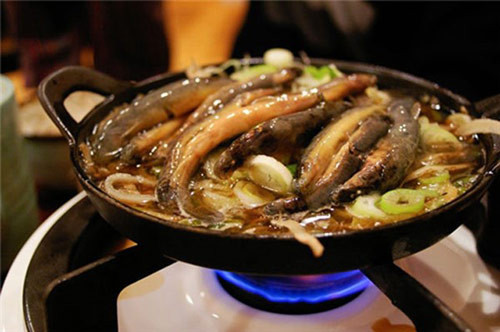 Nguyên liệu: Cá chạch mua về làm sạch nhớt bằng cách vắt chanh và cho thêm một chút muối vào bóp. Tiếp theo cho cá vào nồi đất và một chút dầu ăn, đậy vung lại và đun cho cá chết hẳn, khoảng 3 phút là được. Ảnh: 24h.com.vn.